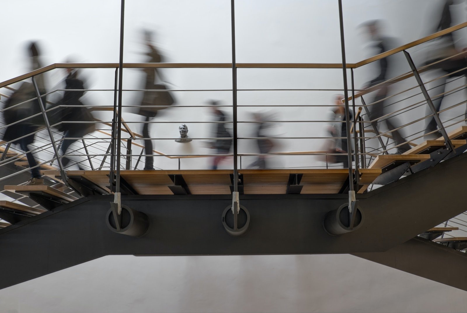 People walking through the upper gallery of an academic building